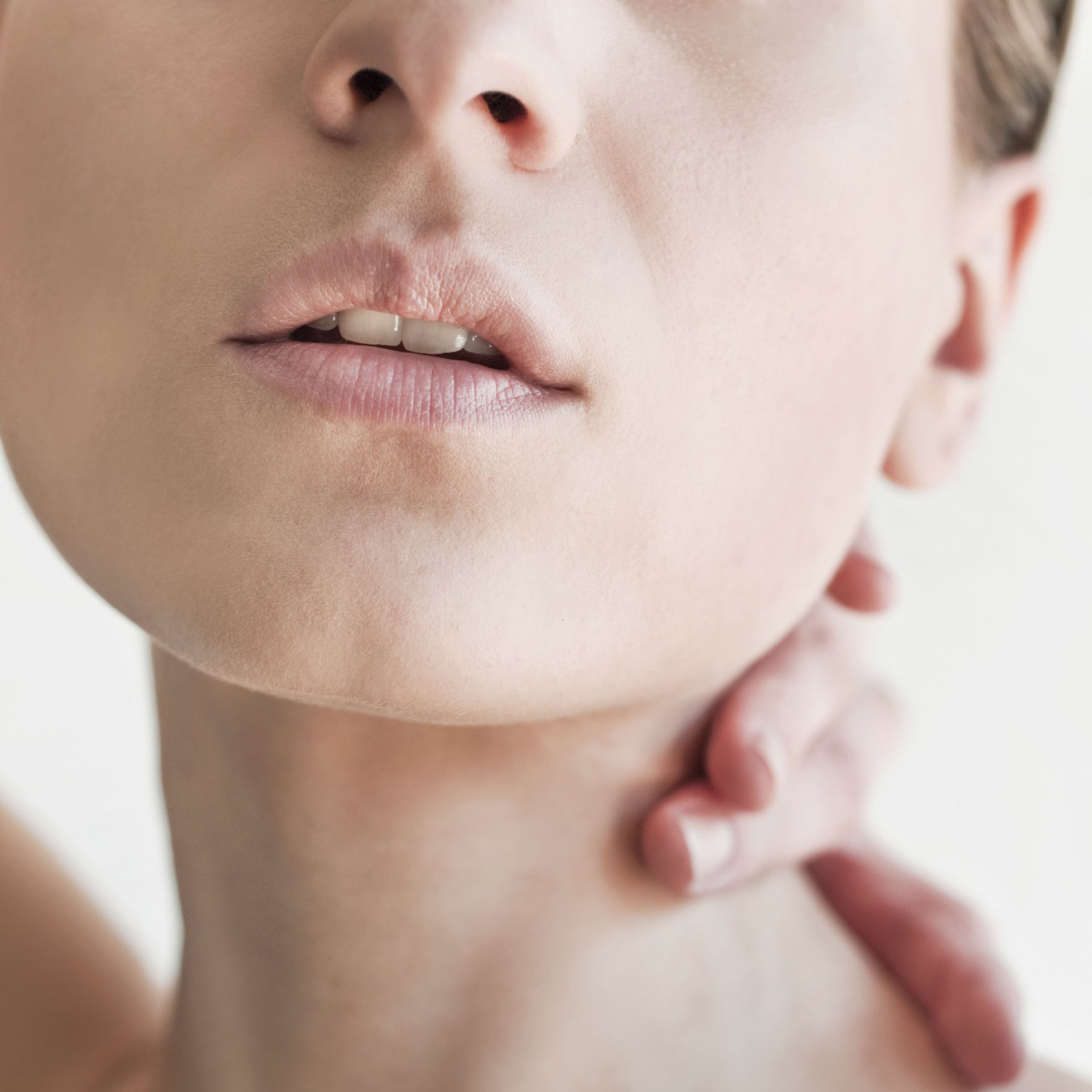 woman with hand on neck